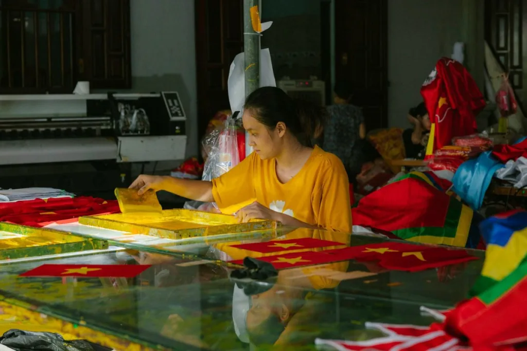 DTF vs Sublimation: 7 Key Differences Every Crafter Must Know A worker printing onto textiles in a workshop, one of the methods compared in DTF vs sublimation
