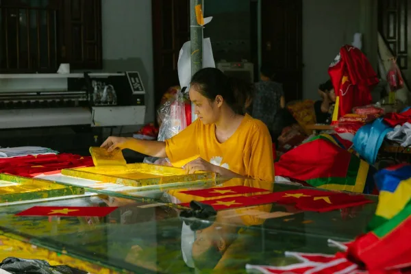 A worker printing onto textiles in a workshop, one of the methods compared in DTF vs sublimation