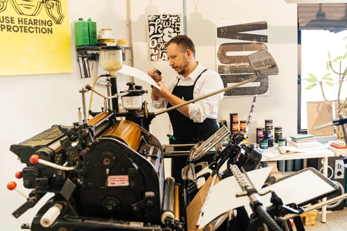 Heat Press Buying Guide: 8 Essential Checks to Avoid a Costly Mistake A maker working at a press in a workshop, the kind of setup a heat press sits in