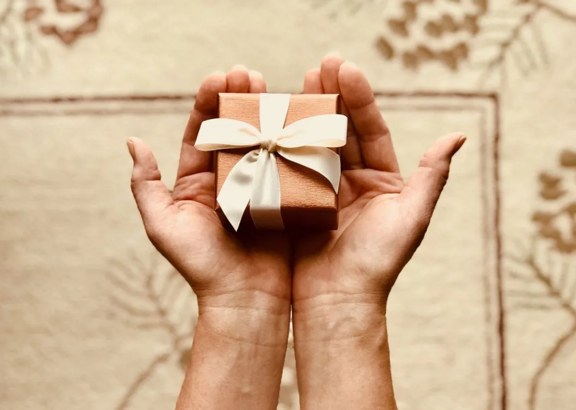 Personalised Gifts: 12 Best Ideas for Every Occasion in South Africa Hands holding a wrapped gift box with ribbon, representing thoughtfully chosen personalised gifts